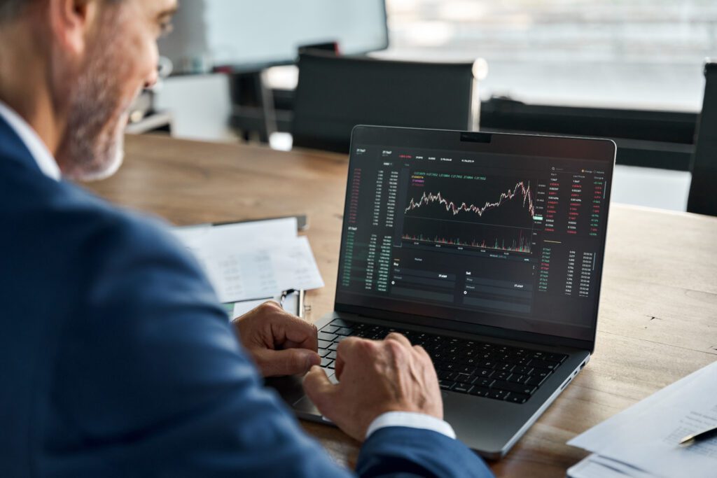 Stock market Investor analyst broker analyzing financial trade crypto stockmarket exchange platform digital chart data on computer screen thinking of investing analytic risk. Over shoulder view. TradingView